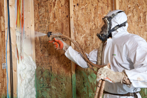 person standing spraying foam over cables