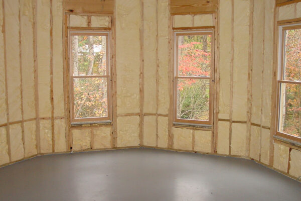 three windows with spray foam applied around them