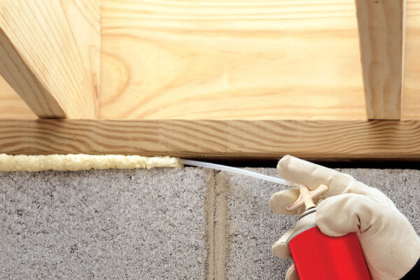 person spraying foam in small crevice