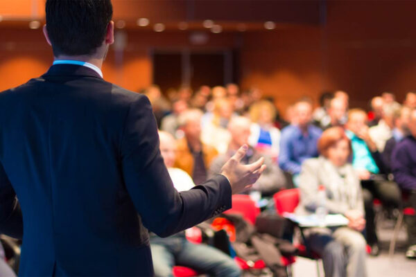 person presenting to room full of people